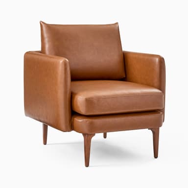 A modern armchair upholstered in brown leather. It features a boxy frame with rounded armrests and a slightly reclined backrest. The seat is composed of two thick cushions. The armchair is supported by four tapered wooden legs, angled outwards. — 3D model