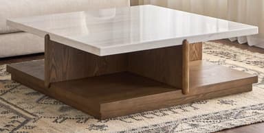 A contemporary coffee table with a square, white marble top featuring subtle grey veining. The base consists of two tiers of dark wood with a prominent grain pattern. The upper tier is supported by the lower tier, with two rounded wooden legs integrated into the structure, connecting the top and bottom shelves. The overall design is minimalist and geometric. — 3D model