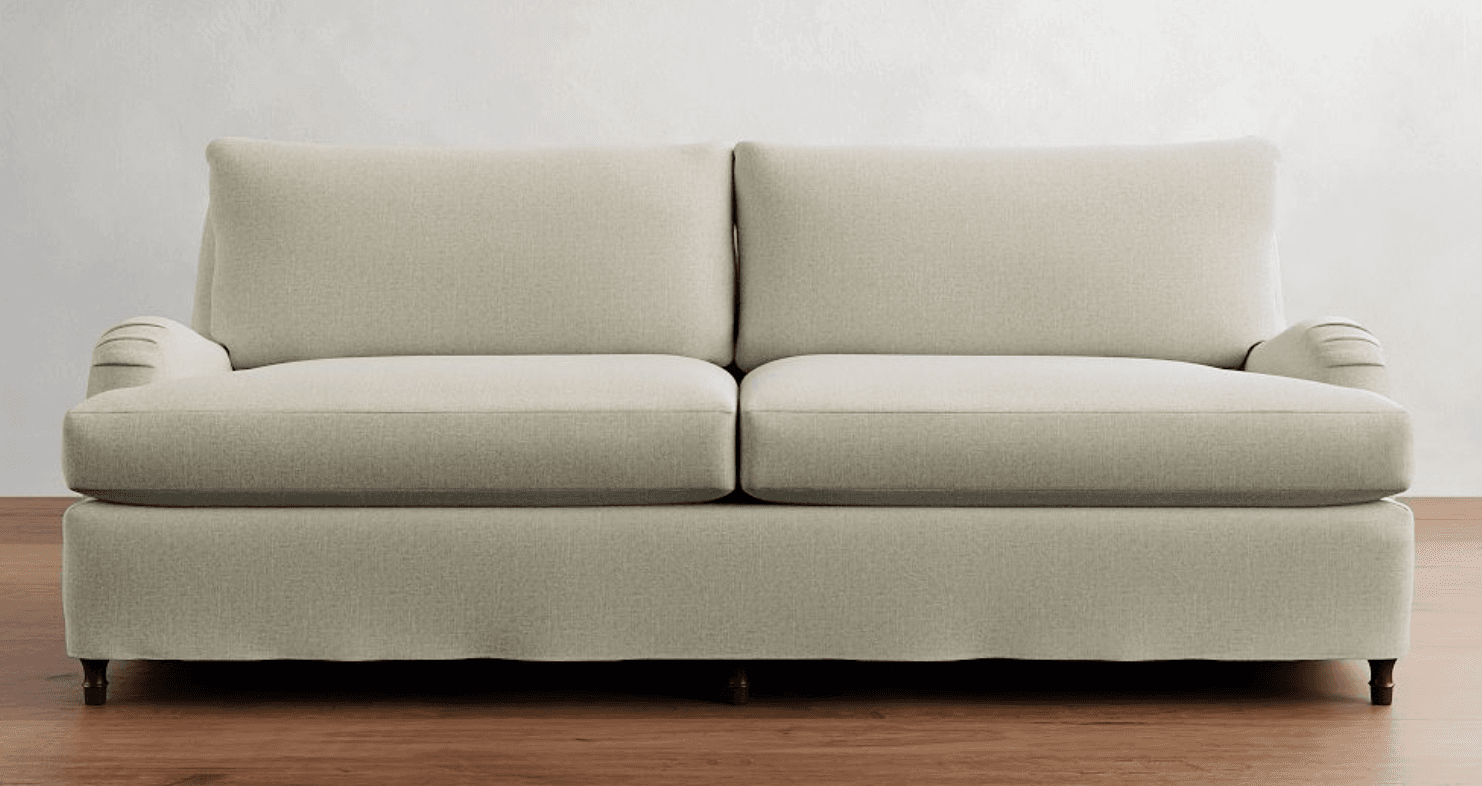 A contemporary sofa upholstered in a light-colored, textured fabric, featuring classic rolled armrests. It is designed with two distinct seat cushions and two matching back cushions, supported by small, dark, exposed legs. — 3D model