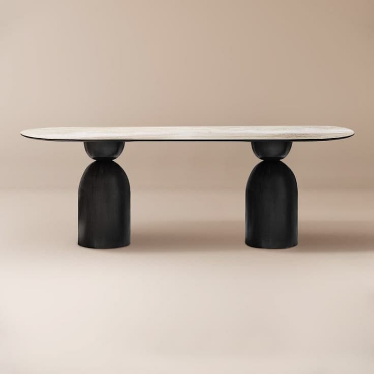 A contemporary coffee table featuring a elongated oval tabletop with a white marble-look surface, supported by two robust, rounded, black drum-shaped bases. The design is minimalist and sculptural. — 3D model