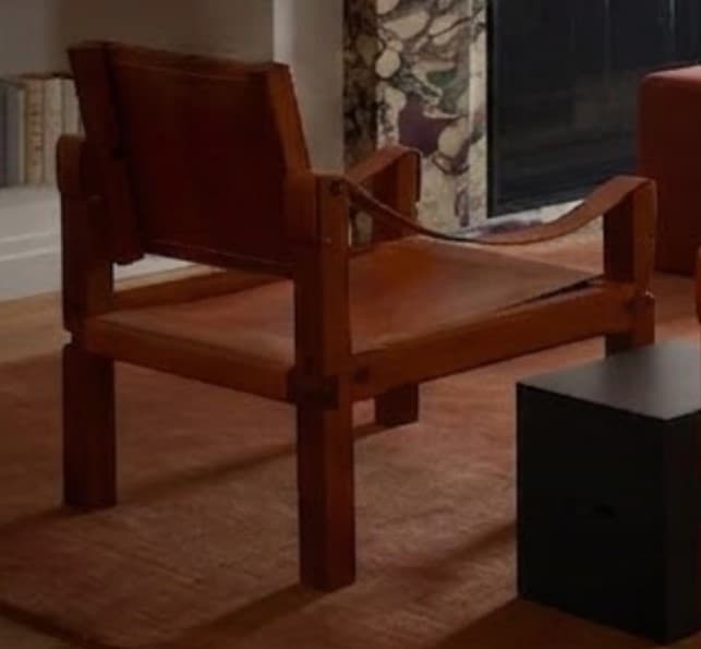 A modern lounge chair featuring a sturdy wooden frame and suspended brown leather elements forming the seat, backrest, and armrests. The design emphasizes natural materials and clean lines, offering a relaxed seating posture. — 3D model