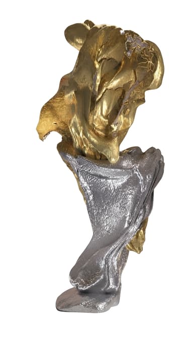 An abstract, modern sculpture featuring an organic, flowing form. It is composed of two distinct metallic elements: an upper section with a rich, textured gold finish and a lower section with a contrasting silver finish. The surface exhibits a highly textured, almost molten or draped quality, creating visual depth and movement. The sculpture stands upright on a subtle base, showcasing a dynamic interplay between its two-tone metallic surfaces. — 3D model