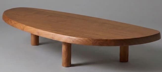 A low-slung wooden coffee table with an elongated, organic oval-shaped top and four thick, cylindrical legs. The entire piece is made of natural light brown wood, featuring visible grain and rounded edges, presented against a neutral gray background. — 3D model