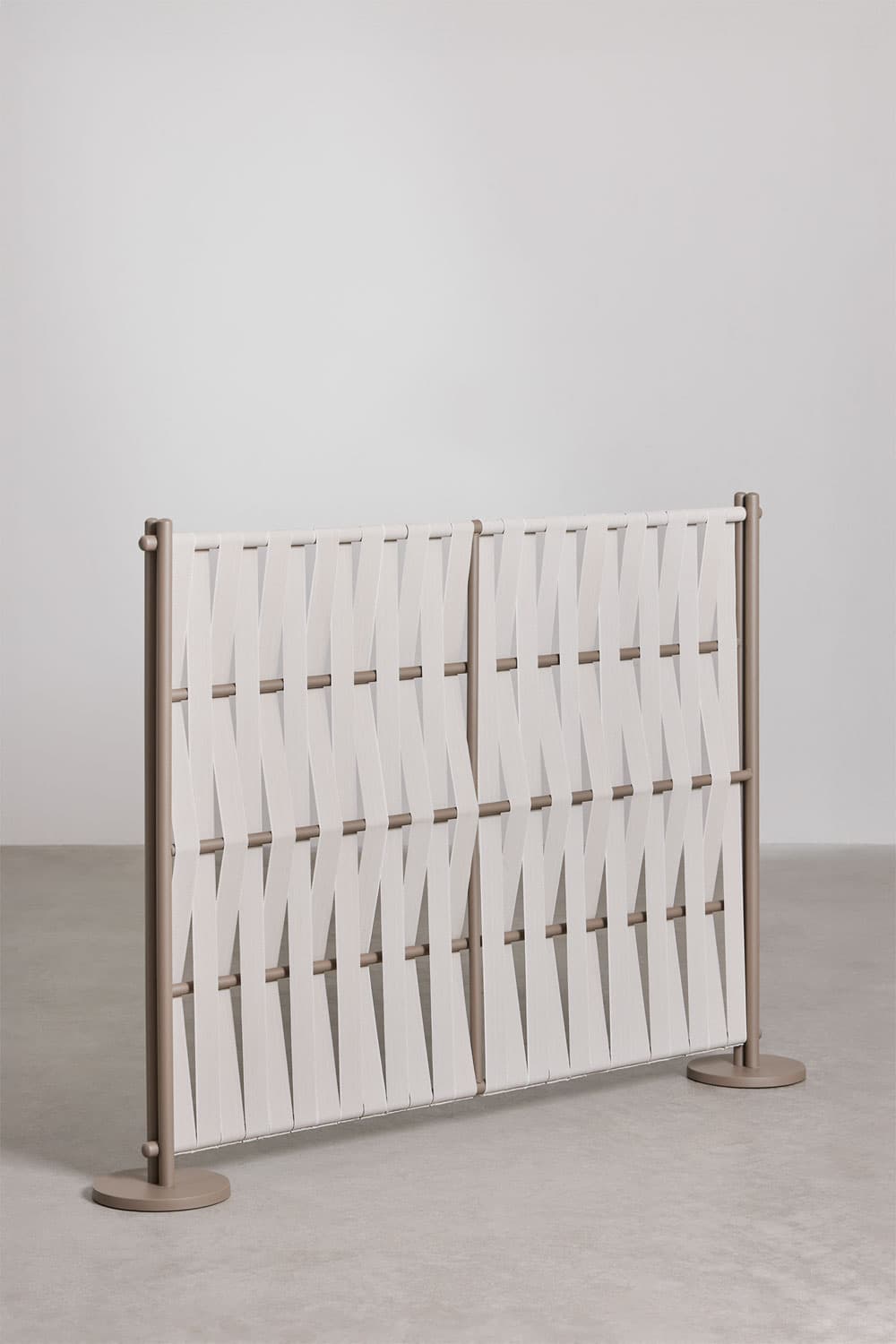 A modern freestanding room divider composed of two rectangular panels. Each panel features a tubular metal frame in a matte taupe color, with horizontal rods through which wide, off-white textile straps are woven in a diagonal, crisscrossing pattern. The divider stands on two flat, circular bases, one at each end. — 3D model