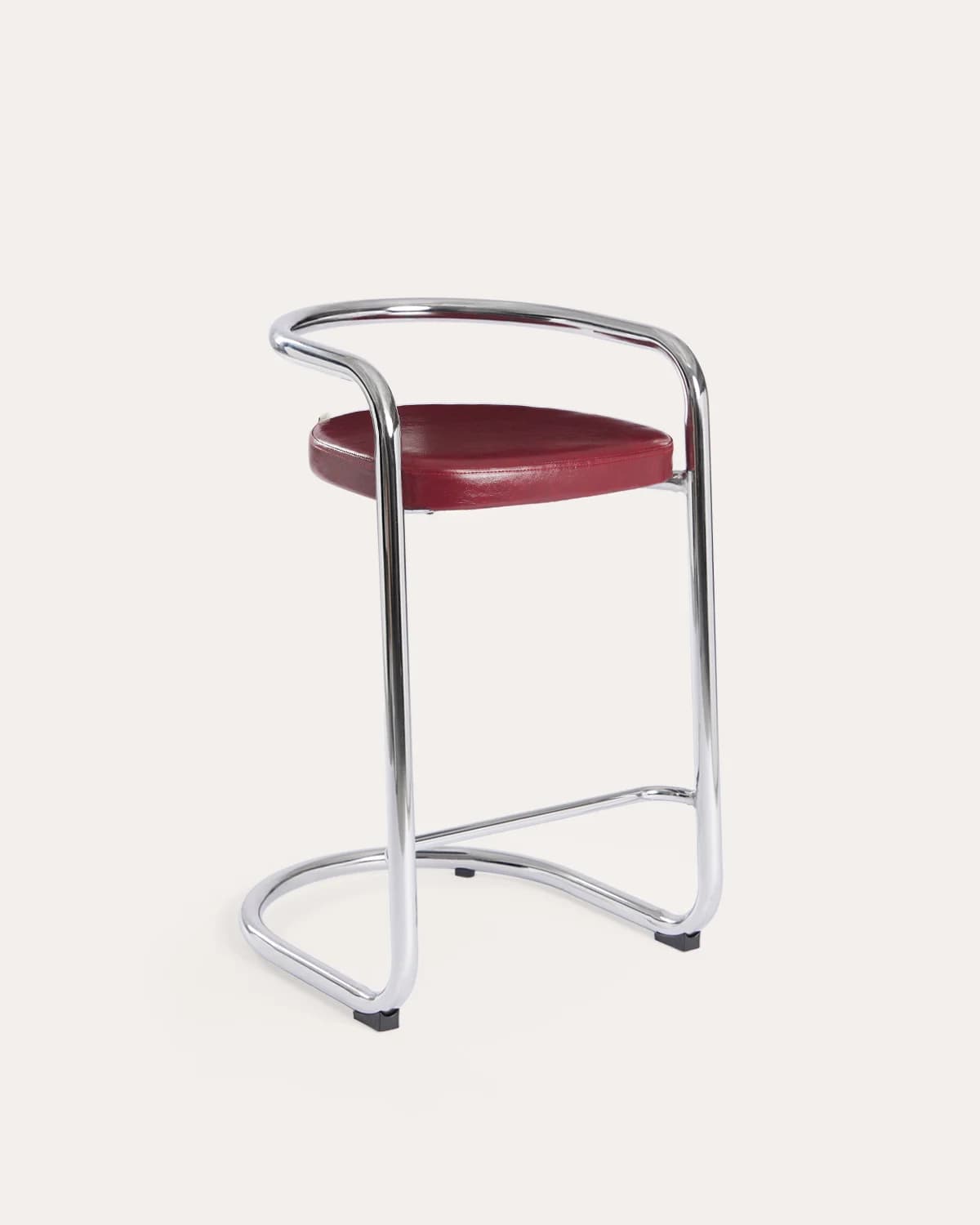 A high bar stool featuring a gleaming tubular chrome frame and a curved, red upholstered seat and backrest. The frame forms a continuous loop from the base, extending upwards to create armrests and a partial back support. The design is sleek and minimalist, characteristic of the Bauhaus and modernist aesthetic. — 3D model