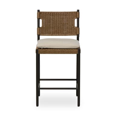 A contemporary bar stool featuring a dark-colored metal frame, a woven synthetic rattan seat and backrest, and a light-colored fabric cushion. The stool includes an integrated footrest for comfort. The backrest has cut-out handles on either side, and the overall aesthetic is clean and modern, suggesting suitability for both indoor and outdoor environments. — 3D model