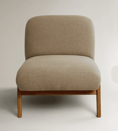 A low-profile armchair with a rounded, upholstered seat and backrest, supported by a minimalist wooden frame. The armchair features a fabric upholstery that appears to be a light beige or off-white color and a visible wooden base with four angled legs. — 3D model