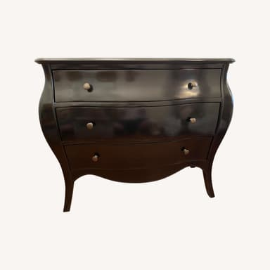 A dark-finished bombe chest of drawers featuring a serpentine top and three bowed drawers, each fitted with antique-style metal knobs. The chest exhibits a curvilinear silhouette with gracefully curved sides and subtle cabriole-style legs, indicative of a Rococo or French Provincial design. — 3D model