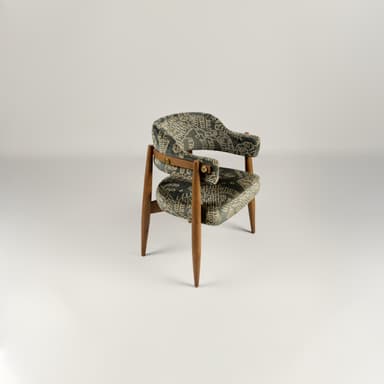 A wooden accent chair with two upholstered seating surfaces. The frame is constructed from light brown wood with tapered legs. The upholstery is a dark fabric with an intricate, possibly embroidered, pattern in a lighter color, featuring scrollwork and geometric motifs. A brass-colored latch or buckle detail is visible on the upper upholstered section. — 3D model