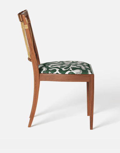 A wooden chair with a curved backrest featuring vertical, cane-wrapped spindles and a padded seat upholstered in a green fabric with a white abstract pattern. The chair has a solid wooden frame with four tapered legs. — 3D model
