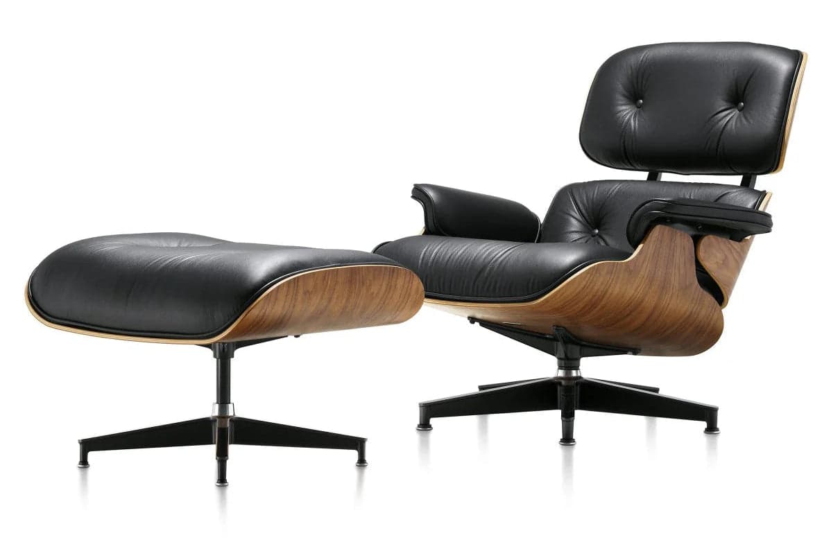 A classic Mid-Century Modern Eames Lounge Chair and Ottoman set, featuring black leather upholstery on molded plywood shells with a dark wood veneer. The chair has a distinctive reclining form with separate back and seat cushions, integrated armrests, and rests on a five-star swivel base. The matching ottoman has a similar molded plywood shell, black leather cushion, and a four-star fixed base. — 3D model
