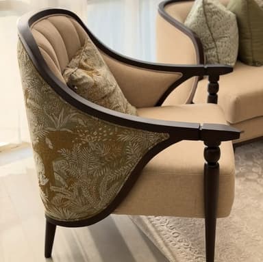 A classically inspired upholstered armchair featuring a curved, exposed dark wood frame, complemented by light beige fabric on the seat and inner back. The outer back and side panels are adorned with a lush green and gold tropical or botanical pattern, and the chair includes a matching decorative throw pillow. — 3D model