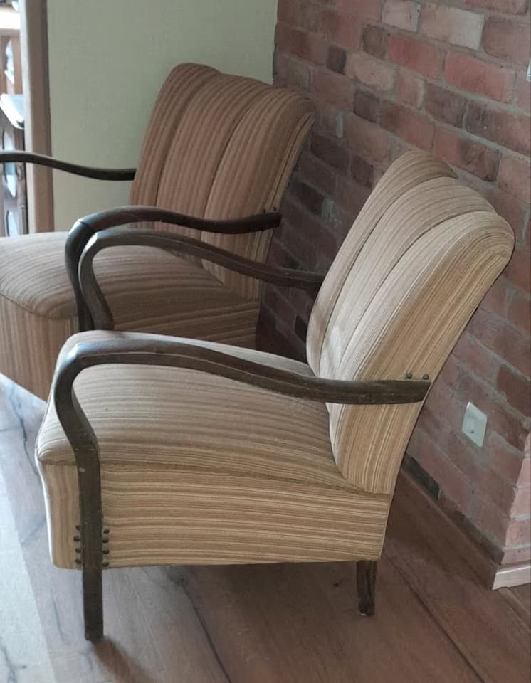 A vintage armchair with a high, channeled back and padded seat. The chair features curved wooden armrests and legs. The upholstery is a striped fabric in neutral tones. — 3D model