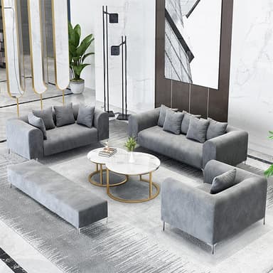 A modern, three-seater sofa upholstered in a grey fabric, featuring rounded track arms, loose back cushions, and slender, minimalist metal legs. It includes additional throw pillows for comfort. — 3D model