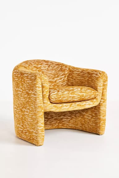 A standalone armchair with a rounded back and seat. The upholstery features a textured pattern in shades of yellow and cream, resembling an abstract animal print or natural fibers. — 3D model