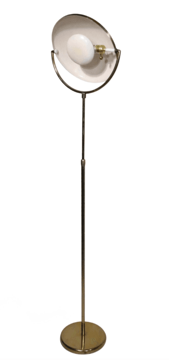 A tall, slender floor lamp constructed entirely from brass, featuring a circular base, a straight stem, and a distinctive dome-shaped shade. The shade appears to be adjustable, mounted on a curved arm that attaches to the main stem. The brass exhibits a polished, reflective finish, suggesting a mid-century modern aesthetic. — 3D model