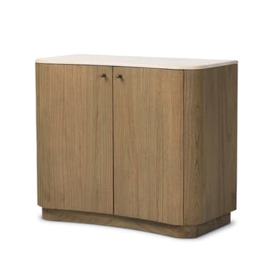 A modern, two-door storage cabinet featuring a light-toned natural wood finish and a contrasting light-colored stone top. The cabinet has distinct rounded edges on its sides and a matching rounded, recessed plinth base, giving it a soft, contemporary silhouette. It includes two hinged cabinet doors, each fitted with a small, circular dark metal knob, suggesting internal storage. The wood grain is visible and consistent across the surfaces, indicating a solid wood or high-quality wood veneer construction. The overall appearance is minimalist and elegant. — 3D model