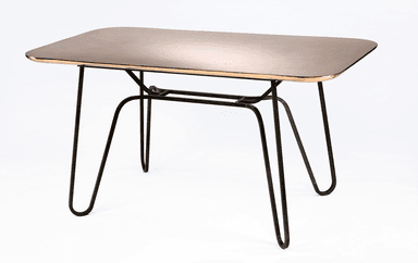A rectangular dining table with rounded corners. The tabletop has a polished, reflective surface with a warm metallic tone, possibly brass or copper, and a distinct gold-toned edge trim. The base consists of four slender, dark-colored metal legs that splay outwards and are connected by a central, minimalist metal frame. — 3D model