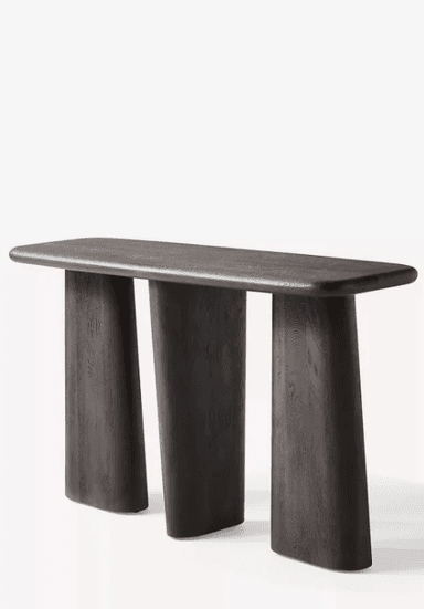 A dark-stained wooden console table featuring a rectangular top with subtly rounded corners. The table stands on three distinct supports: two wider, trapezoidal legs positioned at either end, and a narrower, cylindrical central leg, all tapering slightly towards the top. — 3D model