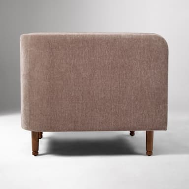 A contemporary upholstered club armchair featuring a single, removable seat cushion, integrated flared arms, and a low back, all covered in a textured, brown fabric. The chair stands on four tapered wooden legs. — 3D model