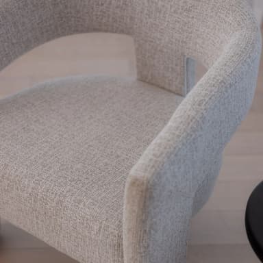 A modern armchair with a curved backrest and straight arms. The chair is upholstered in a textured fabric and features sturdy, rectangular legs. — 3D model