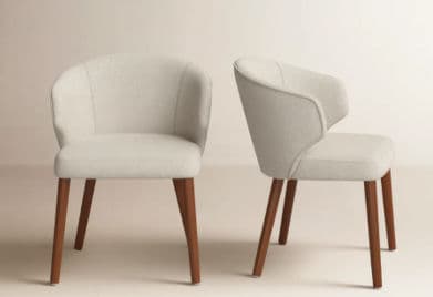 An upholstered armchair featuring a rounded, continuous backrest that flows into integrated armrests. The seat is padded, and the chair is supported by four splayed, tapered wooden legs. — 3D model