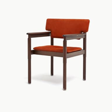 A contemporary armchair featuring a dark wood frame and rust-colored upholstered seat and backrest. The backrest is rectangular with cut-outs to accommodate the rounded wooden armrests, which extend from the rear support posts. The legs are cylindrical and straight, connected by stretcher bars beneath the seat. The seat cushion is subtly tufted. — 3D model