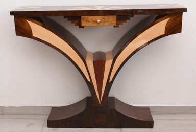 An elegant console table featuring a dark wood finish adorned with intricate marquetry. The rectangular tabletop displays a central sunburst pattern, flanked by geometric designs in contrasting lighter wood. The table's base consists of two large, sweeping curved supports that meet at a central point and transition into a sturdy, ornate plinth. These legs are also embellished with contrasting wood inlays that highlight their graceful, sculptural form. A single, small drawer with a simple pull is subtly integrated beneath the tabletop. — 3D model