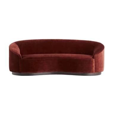 A curved sofa with a plush velvet upholstery in a deep reddish-brown hue. The sofa features a rounded silhouette with integrated armrests and a low-profile base. The base appears to be made of a darker material, possibly wood or metal, with a smooth finish and a slightly curved profile that mirrors the overall shape of the sofa. — 3D model