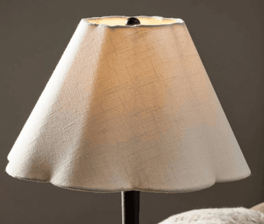A tall, slender floor lamp with a conical lampshade and a weighted base. The lamp features a dark-colored, possibly metal, stem with a subtle tapered design near the middle. The lampshade is light-colored and appears to be made of fabric. — 3D model