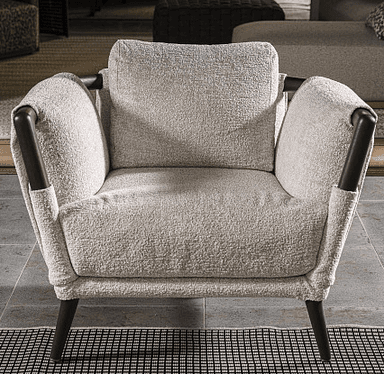 A contemporary armchair with a fabric-covered frame, featuring a textured weave. It has a prominent wooden frame visible at the arms and back, with tapered wooden legs. A square throw pillow rests on the seat. — 3D model