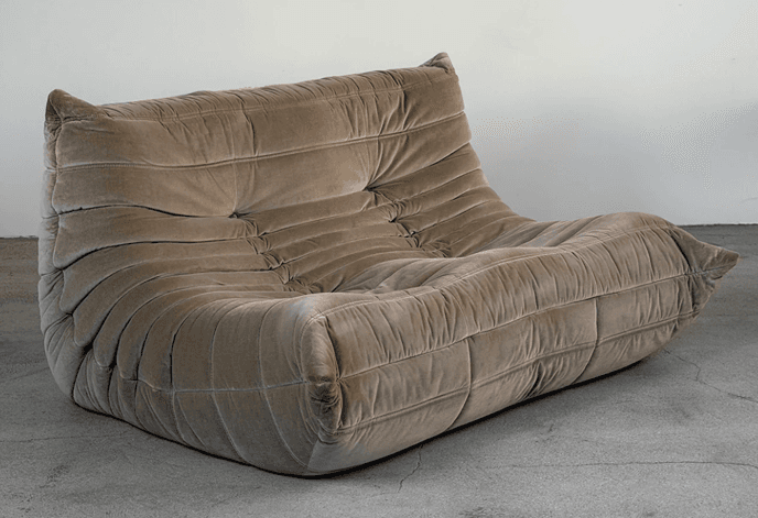 A low-profile, two-seater sofa with a distinctive all-foam construction and an ergonomic design, upholstered in a plush, taupe-colored velvet fabric with a gathered, pleated, and tufted appearance. — 3D model