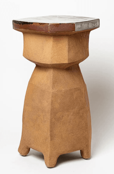 An octagonal pedestal table featuring a faceted, unglazed ceramic body in an earthy brown tone, topped with a smooth, glazed surface displaying a marbling pattern of white, brown, and green hues. The body has a roughly textured, almost Brutalist appearance, with its geometric angles creating a sculptural form. The base of the pedestal flares out slightly to form four integrated feet. The glazed top exhibits characteristic drips and variations where it meets the unglazed body. — 3D model