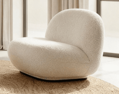 An armless lounge chair upholstered in a cream-colored boucle fabric, featuring a rounded, organic silhouette and a low profile base. — 3D model