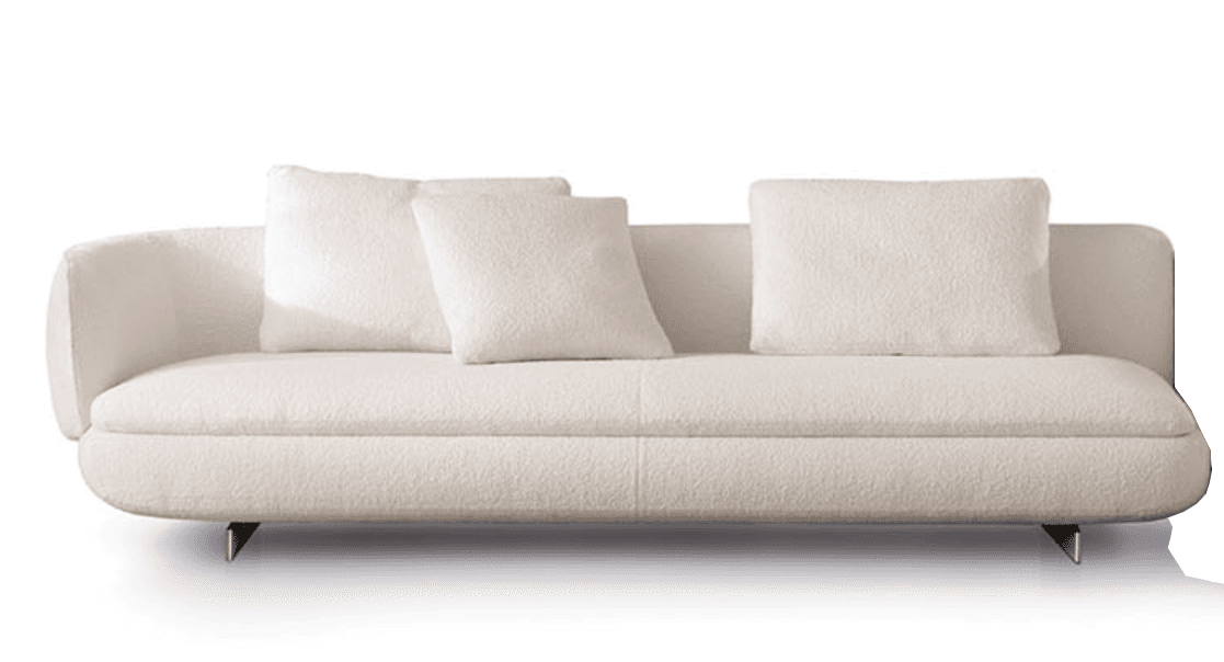 A contemporary sofa upholstered in a creamy off-white boucle fabric, featuring a distinctive asymmetric design with a gently curved, integrated armrest on the left side and a low, straight back on the right. The sofa has a low-profile silhouette with a single, deep seat cushion and loose back cushions. It is supported by subtle, recessed metal legs. — 3D model