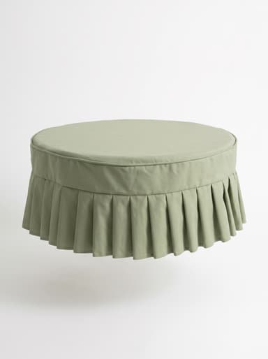 A round, light green upholstered ottoman featuring a pleated skirt base and a flat cushioned top. — 3D model
