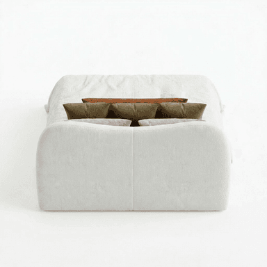 A bed with a curved, upholstered headboard and a light-colored textured comforter. It is adorned with several decorative pillows: a long lumbar pillow in a rust color, and three square pillows in an olive green hue, arranged behind the lumbar pillow. The bed appears to be a queen or king size. — 3D model