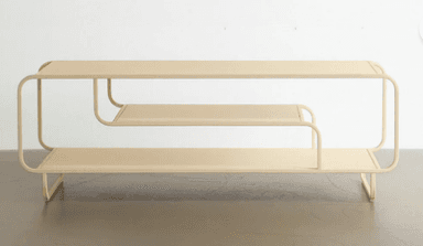 A low, two-tiered shelving unit made from tubular metal with flat shelves, featuring a continuous, bent frame with rounded edges and finished in a light beige color. — 3D model