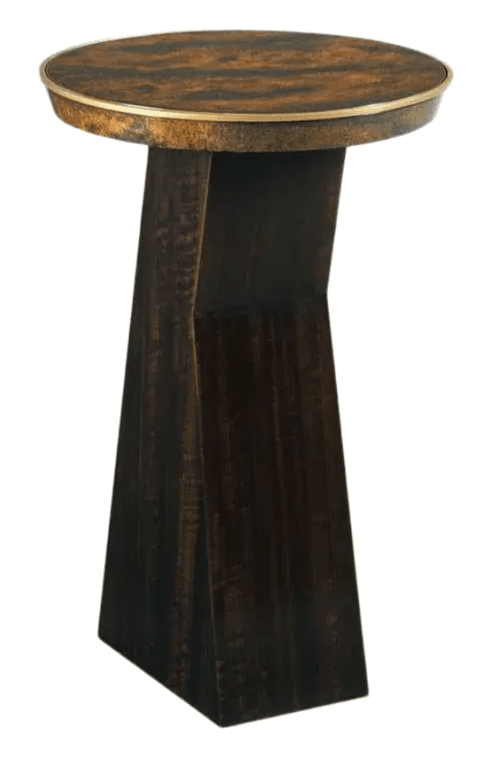 A round accent table featuring a patinated metallic top with a raised rim, supported by a distinctively geometric, dark-finished wooden pedestal base. The top exhibits a mottled, copper-like texture, suggesting a rustic or industrial aesthetic. The base is composed of angular, intersecting planes of dark wood, providing a modern architectural contrast to the distressed top. — 3D model