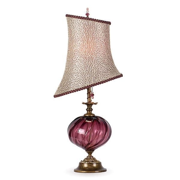 An ornate table lamp featuring a twisted, swirled purple glass body, an antiqued brass base and neck, and a unique angled fabric lampshade. The shade has a textured, possibly animal-print or distressed pattern, trimmed with a decorative border and topped with a small finial adorned with beads. The overall aesthetic is elaborate and decorative. — 3D model
