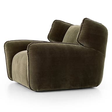 A plush, olive green velvet upholstered lounge chair featuring rounded, integrated armrests and a high back with soft, wing-like side panels. The chair's design emphasizes comfort with its deep seating and soft, inviting contours, highlighted by subtle piping along the seams. — 3D model