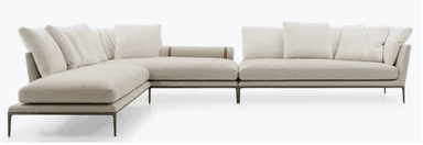 A contemporary light beige sectional sofa with a chaise lounge, supported by a minimalist black metal frame and slender legs. It features deep cushions and multiple loose back pillows, with a distinctive cylindrical armrest detail. — 3D model