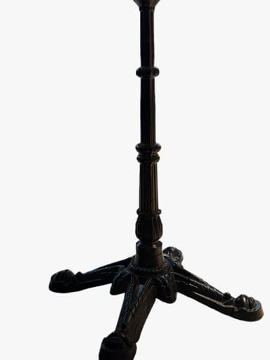 An ornate cast iron table base designed for a bistro or cafe table. It features a central fluted column with decorative rings, resting on a four-legged star-shaped base. Each leg is intricately scrolled and culminates in a paw-like foot. The base is finished in a dark, likely black, color, giving it a classic and robust appearance. The top of the column includes a flat plate with pre-drilled holes for attaching a tabletop. — 3D model
