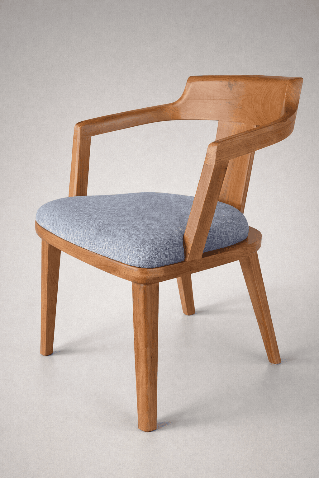 A wooden armchair with a padded seat. The chair features a distinctive curved backrest that flows into the armrests. The legs are tapered and made of solid wood. The seat is upholstered in a textured fabric. — 3D model