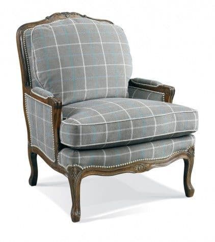 A wingback armchair with a carved wooden frame and upholstered seat, back, and arms in a grey plaid fabric. The frame exhibits ornate carving and is accented with decorative nailhead trim along the edges of the upholstered sections. The legs are cabriole style and are also carved. — 3D model
