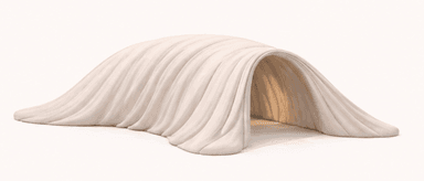 A beige, arch-shaped bench that appears to be made of a soft, pliable material. The bench has a smooth, matte finish with visible vertical pleats or folds that drape from the arch's apex to the base, creating a sense of soft drapery. The interior of the arch is hollow, suggesting it could be a functional bench with a unique, sculptural form. — 3D model
