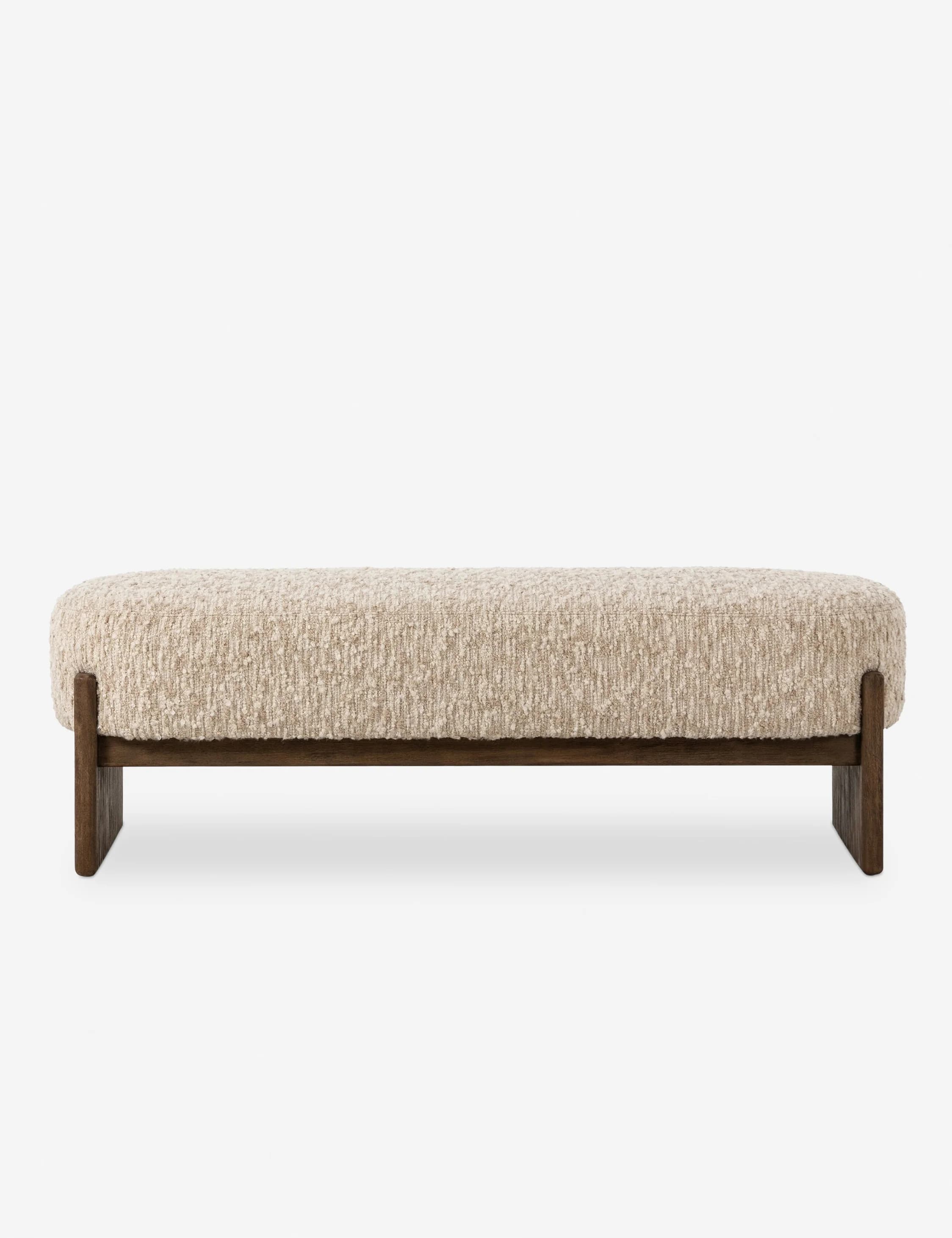 A long, upholstered bench with a textured, boucle-like fabric in a neutral off-white color. The bench features a solid, dark wood frame with a minimalist design. The frame consists of two horizontal pieces connecting the legs, which have a subtle, angled profile. — 3D model