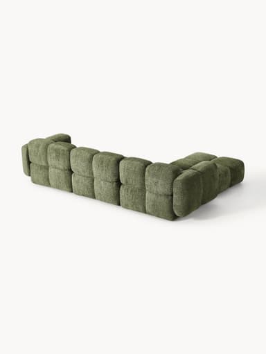 A modular sectional sofa composed of multiple cubic upholstered units. The sofa features a low profile and rounded edges on each module, creating a soft, organic aesthetic. It is upholstered in a textured, boucle-like fabric in a muted green hue. The arrangement suggests a configuration that includes a corner section and extended seating. — 3D model