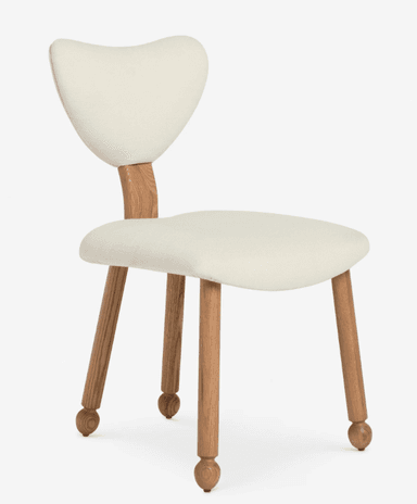 An armless dining chair featuring an off-white upholstered seat and a distinctive sculpted backrest. The backrest is connected to the seat by a rectangular wooden support. The chair stands on four tapered wooden legs, each terminating in a spherical foot detail. The upholstery appears to be a textured fabric, possibly boucle or a similar weave, in a light cream or off-white color. The wood has a natural finish, showcasing its grain. — 3D model