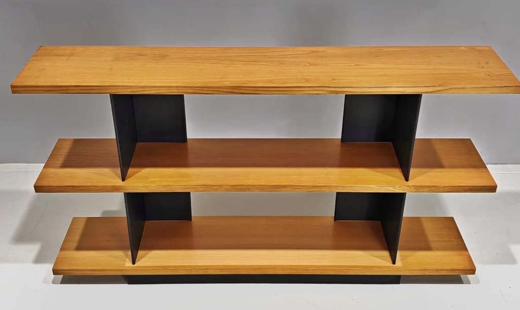 A modern, multi-tiered console table featuring three horizontal wooden shelves supported by contrasting vertical black elements. The top shelf extends over the middle, which in turn extends over the base, creating a cantilevered and layered appearance. The black supports are angled, providing a geometric and stable structure. — 3D model